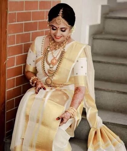 White saree with golden on sale jewellery