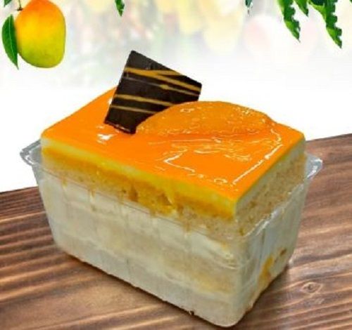 Rectangle Shaped Spongy Fresh And Eggless Mango Cake With Chocolate Topping 